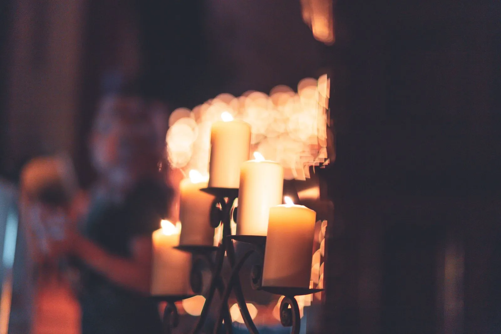 Rows of lit candles glowing in the dark, illustrating festival candlelight traditions